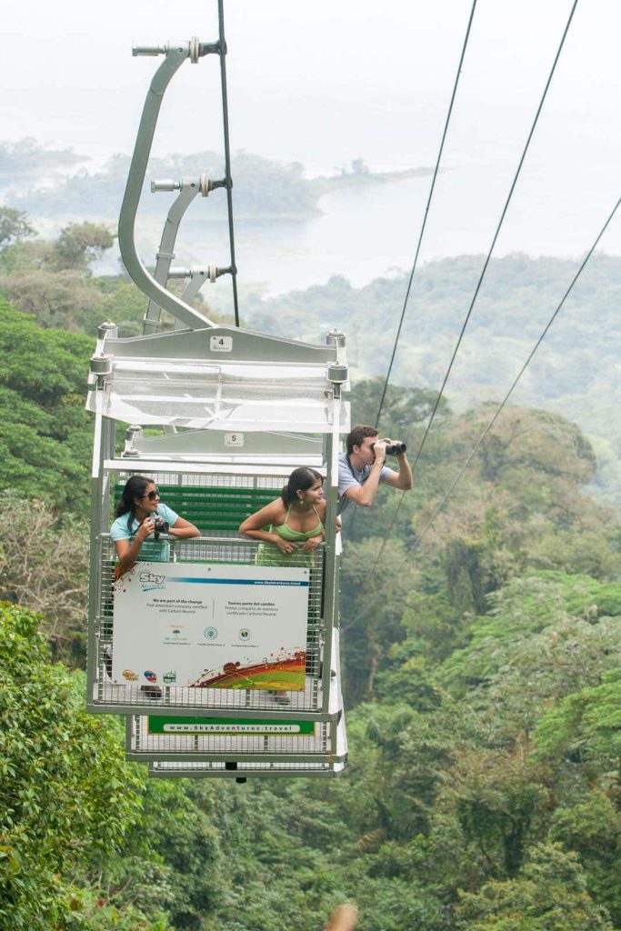 Aerial tram over lush rainforest canopy.