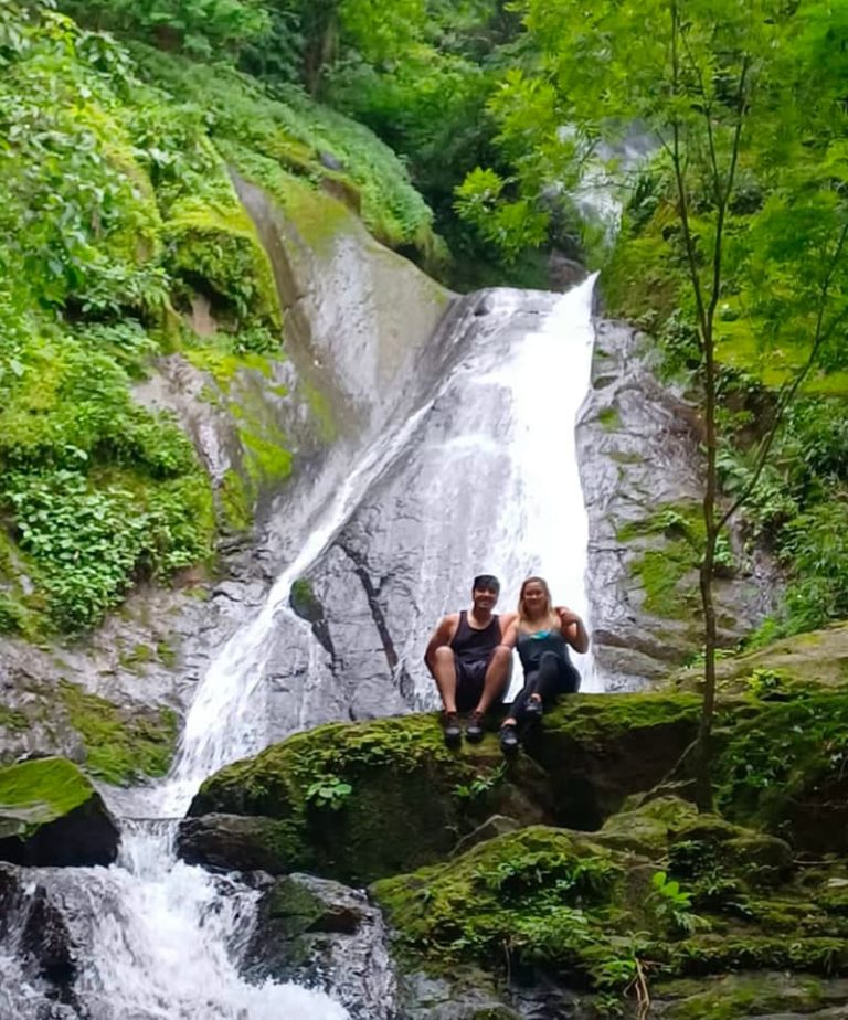 Couple sitting by a waterfall.
