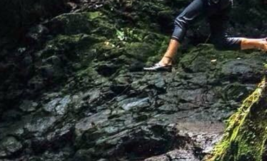 Person jumping over a waterfall