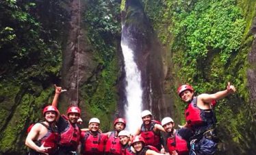 Group posing near a waterfall.
