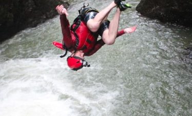 Person jumping into waterfall pool