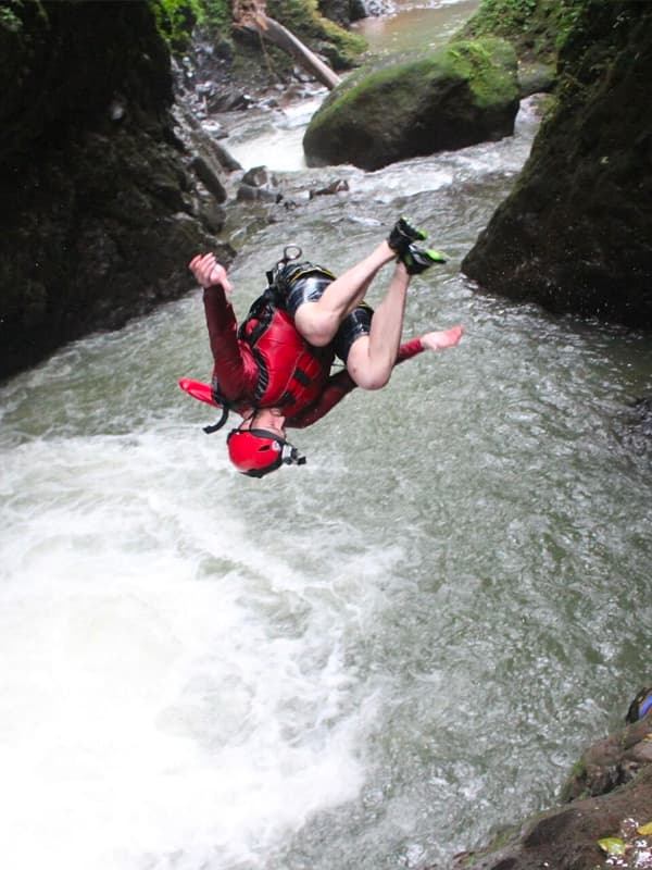 Person jumping into waterfall pool