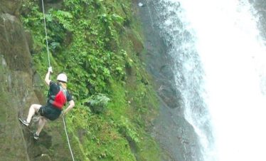 Person rappelling down a waterfall