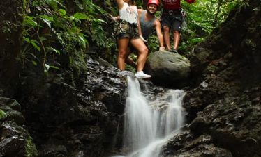 People near a waterfall in nature.