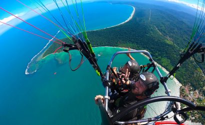 Aerial view of paratrike over coastline.