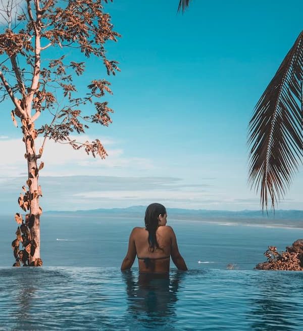 Woman in infinity pool overlooking ocean