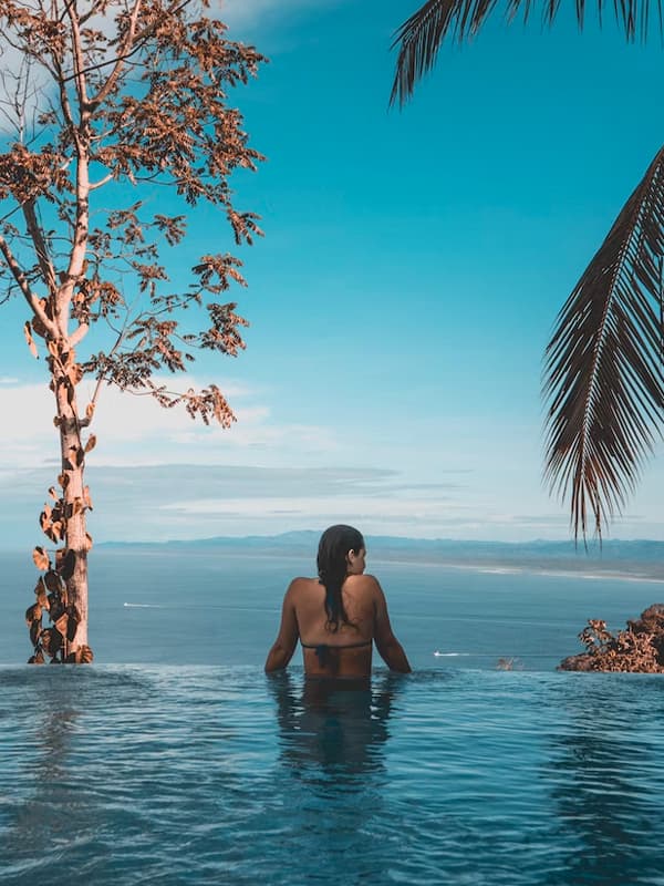 Woman in infinity pool overlooking ocean