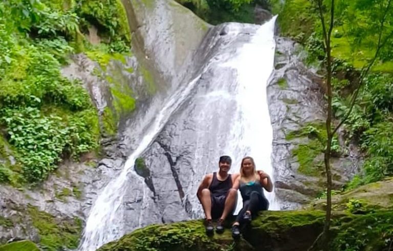 Couple sitting by a waterfall.