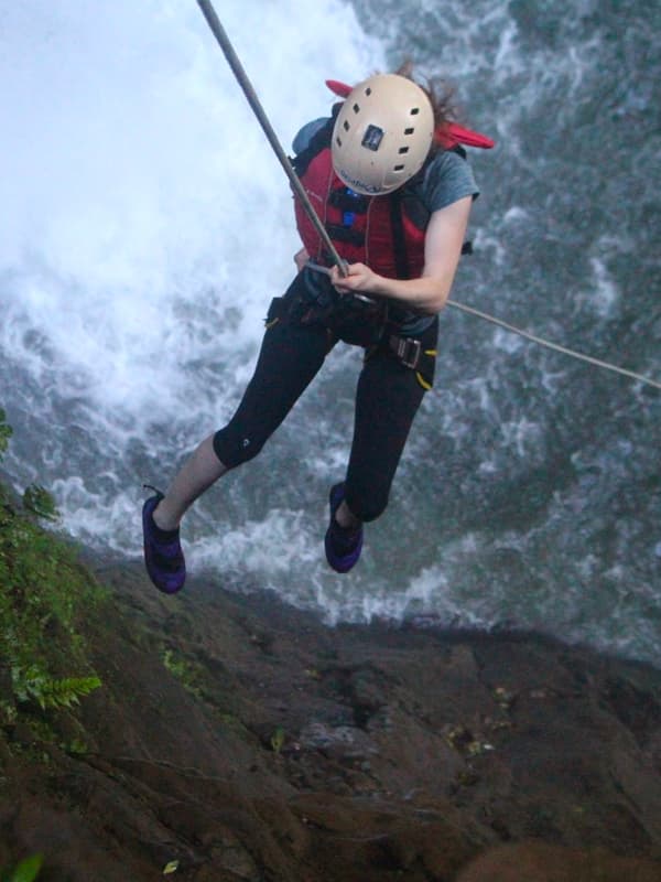 Person rappelling down a waterfall