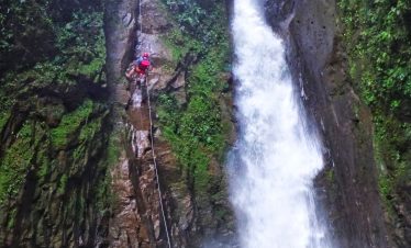 Person rappelling down a waterfall.