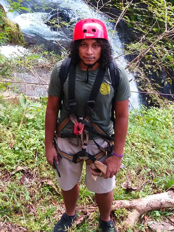 Person in climbing gear by waterfall