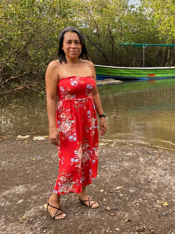 Woman in red floral dress outdoors.